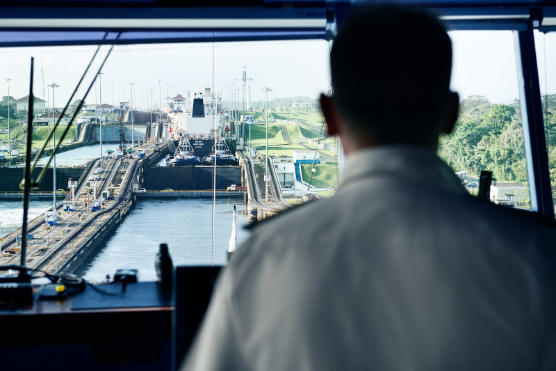 Captain navigating cruise ship, Panama Canal. Ship controls, bridge view, canal transit.