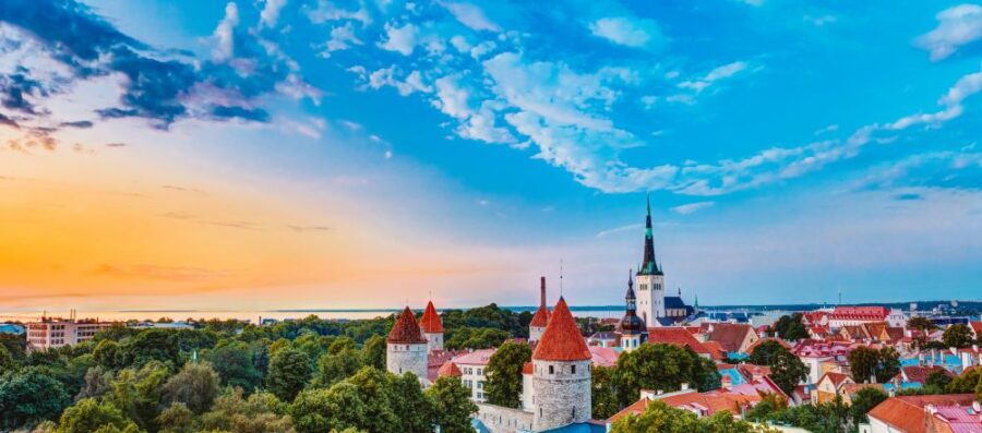 A scenic view of Tallinn, Estonia, featuring its historic red-tiled rooftops, church spires, and medieval architecture.