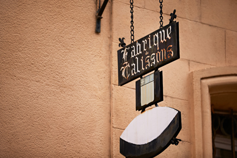 A charming street sign in Aix-en-Provence, Marseilles, surrounded by lush greenery and vibrant flowers, showcasing local culture.