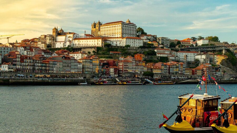 Scenic view of Porto, Portugal, with the Douro River and traditional boats in the foreground.