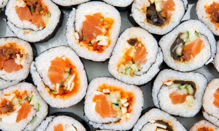 Close-up of salmon sushi rolls on a plate. Rice, seaweed, raw salmon visible. Japanese cuisine.
