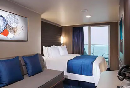 A comfortable balcony cabin on the NCL Epic cruise ship. Features a double bed, sofa, and private balcony with ocean views. Modern and relaxing.