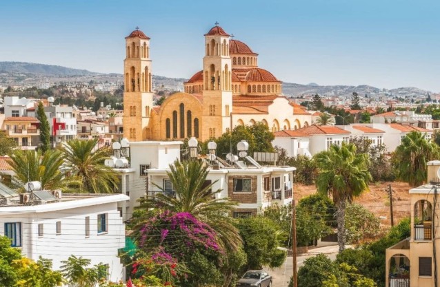 A church in Paphos, Cyprus, with a red-tiled roof and two bell towers.