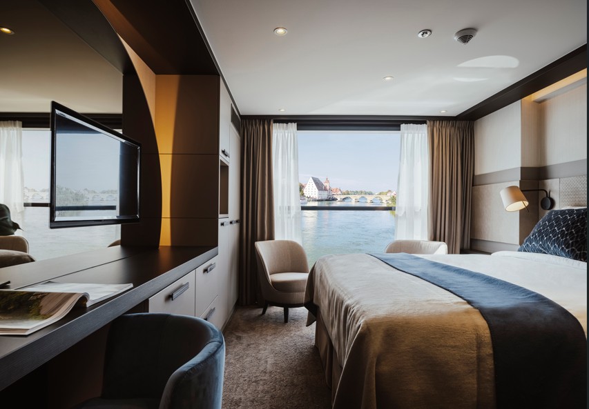 Comfortable and stylish interior cabin on a Balkan adventure cruise. A plush bed, seating area, and modern amenities offer a relaxing retreat. Experience the journey in comfort and style.