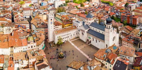 Piazza Duomo in Trento, Italy, an aerial view of the historic square with the Cathedral and Palazzo Pretorio, surrounded by classic buildings.